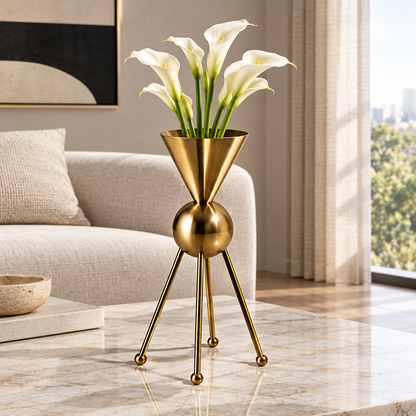 Gold-tone sculptural vase with a cone-shaped vessel, spherical center and slender legs, styled with white calla lilies
